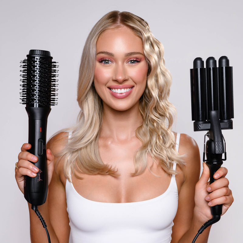 Model holding Mermade Hair Blow Dry Brush in Sleek Black and Style Wand